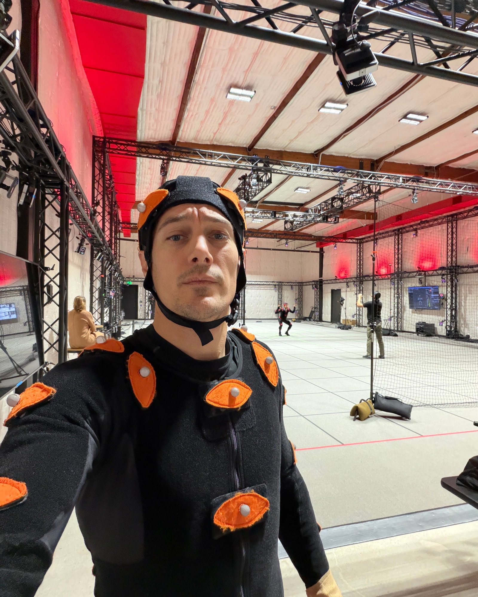 Bryan Jordan in a motion capture suit and marker cap, standing in the mocap volume.